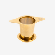 Gold Dakys tea infuser made of stainless steel with fine mesh and drip tray – premium accessory for a perfect performance drink or tea ritual.